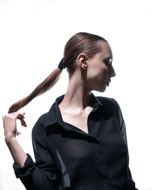 Charmé de Cheveux glossy black — flatlay on dark surface