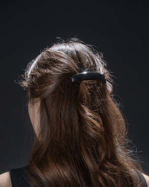Jonc Majesté Barrette glossy black — flatlay on marble, editorial styling