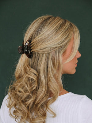 Model wearing Sacrae Eva Small Claw Clip in Tortoise, half-up hairstyle, back view