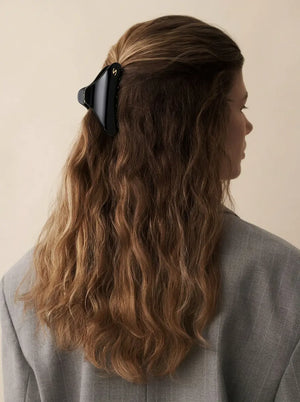 Model wearing Sacrae Large French Yoga Hair Clip in Glossy Black, half-up hairstyle, back view