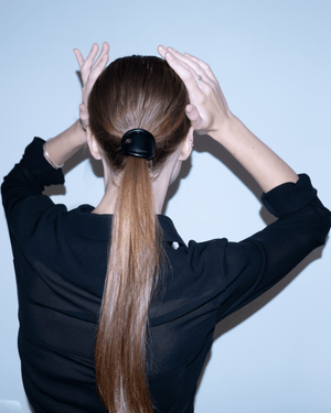 Charmé de Cheveux glossy black — S medallion and chain detail close-up