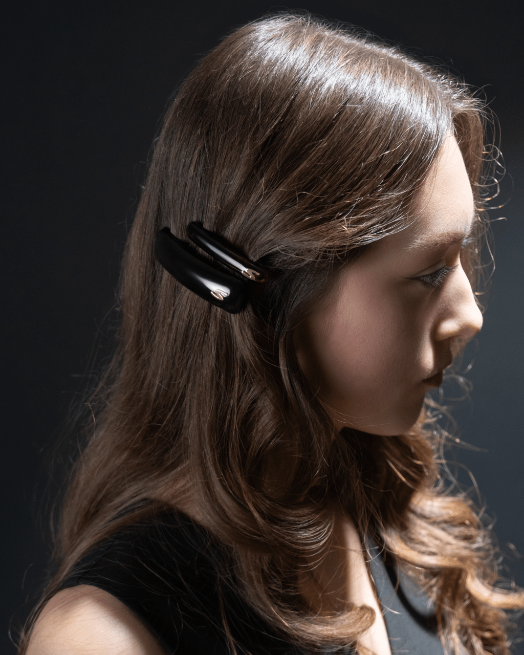 Jonc Slim Barrette glossy black — editorial flatlay, dark editorial surface