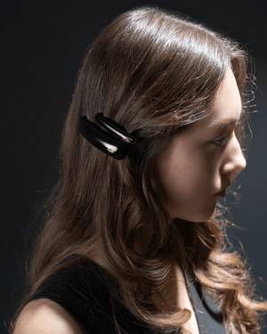 Jonc Slim Barrette glossy black — editorial flatlay, dark editorial surface