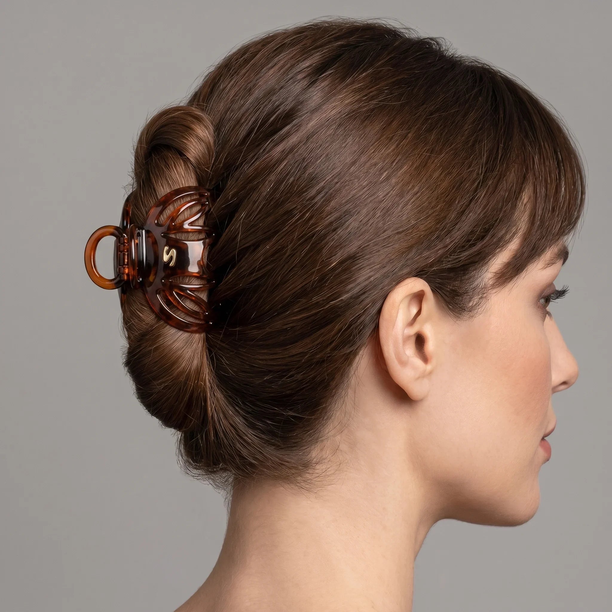 Model wearing Sacrae Lena Small Claw Clip in Tortoise at the temple, studio portrait