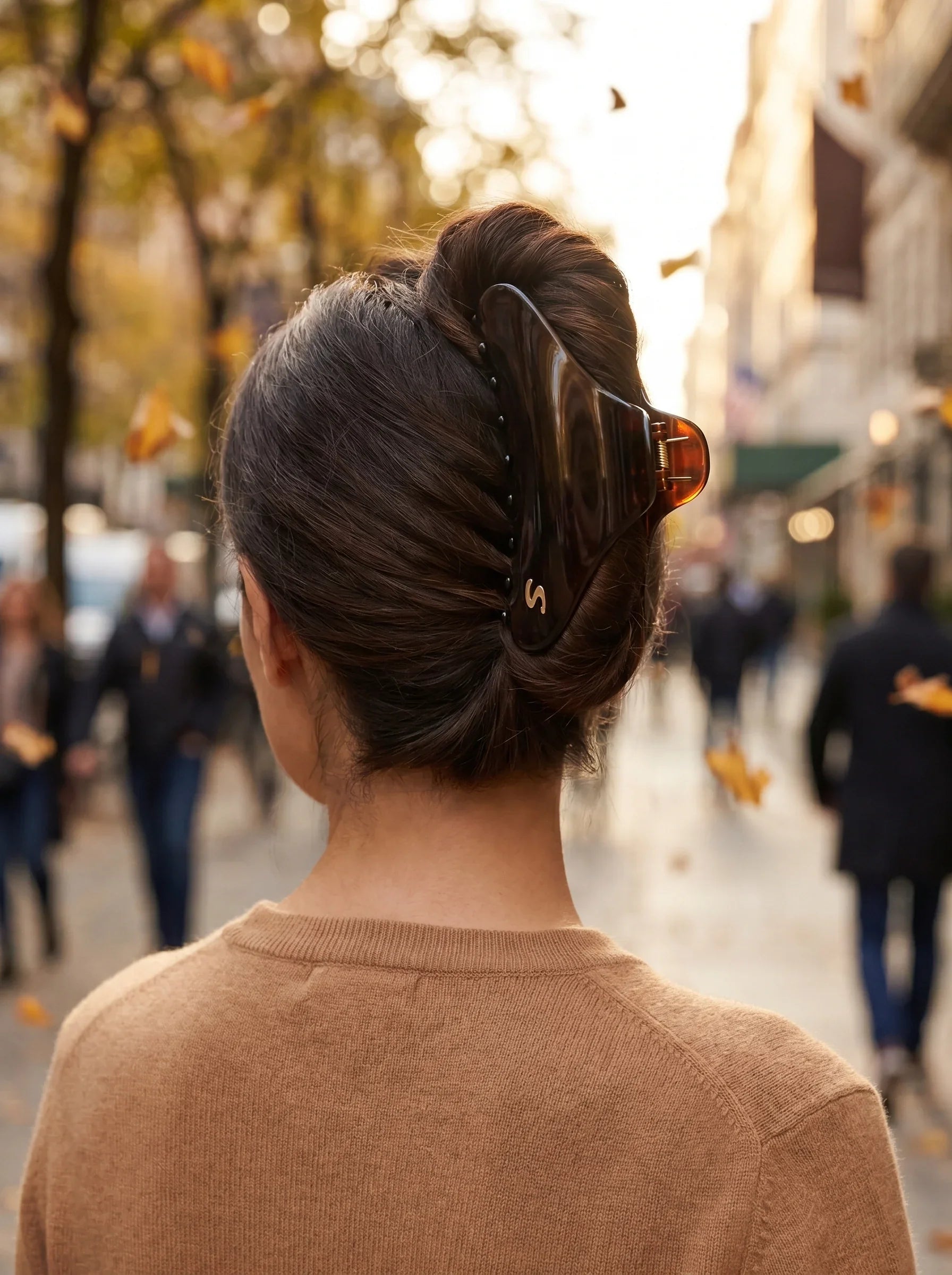 Model wearing Sacrae Large French Yoga Hair Clip in Tortoise, twisted updo, autumn street